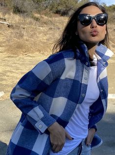 a woman wearing sunglasses and a blue checkered jacket