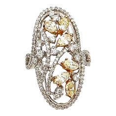 This stunning ring boasts beautiful natural yellow diamonds as the main stones, with a combined total of 131 diamonds. The 2.16 total carat weight and 18k white gold band make for a luxurious and timeless piece. The marquise shape of the main stones adds a unique touch, while the VS2/SI1 clarity grade and F/G color grade of the diamonds ensure exceptional brilliance. Sizable to fit a ring size of 6.5, this fine jewelry piece is perfect for any occasion. Made in the United States with high-quality craftsmanship, this ring is sure to impress. Luxury Multi-stone Yellow Diamond Ring, Yellow Multi-stone Diamond Ring, Yellow Diamond Ring, Yellow Diamonds, Yellow Diamond Rings, Color Grading, White Gold Band, Yellow Diamond, Gold Band