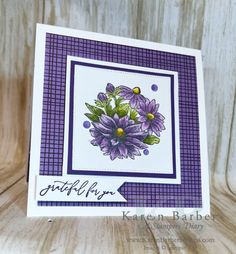 a close up of a card with flowers on the front and purple plaid around the edges