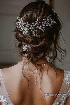 the back of a woman's head wearing a bridal hair comb with flowers on it