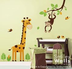 a baby's room with a giraffe and monkey wall decals