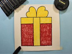 a drawing of a present with crayons next to it