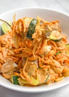 a white bowl filled with noodles and vegetables