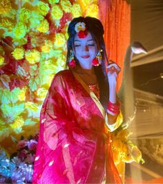 a woman dressed in colorful clothing holding a cell phone to her ear