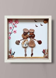 an image of two people holding hands in a frame with rocks and flowers on it