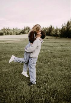 two children are playing in the grass with one holding on to the other's back