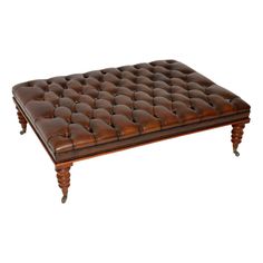 a brown leather ottoman sitting on top of a wooden table