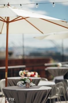 an outdoor dining area with umbrellas and tables set up for guests to sit at