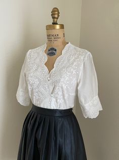 "This is a gorgeous women's white short sleeve, fitted cotton eyelet blouse. This will fit a size medium to large; the bust measures roughly 38\". This has a button-down bodice and charming sleeves! +Not part of the wholesale deal+ Please use my measurements to guide you, all sales are final. The measurements were taken with the shirt laying flat. ✂ - - - Measurements Length- Approx. 22-1/2\" Laying flat measuring from the shoulder down to the hem Bust- will fit approx. 38\" measuring at the arm Cottagecore Blouse, 60s Women, Victorian Blouse, White Cotton Blouse, Skirt With Buttons, Eyelet Blouse, Boho Blouse, Cotton Blouse, Blouse White