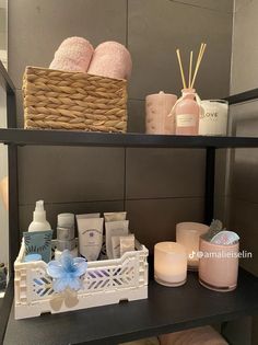 the shelf in the bathroom is filled with soaps, candles and personal care items