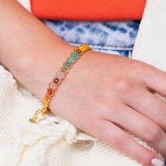 a woman's hand wearing a colorful bracelet