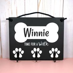 a black and white sign that says winnie time for a walk with paw prints