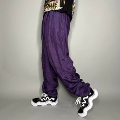 "Vintage Nylon Track Pants Grape Purple Joggers Baggy Fit Elastic Cuffs has Ankle Zippers Lined 90s Skate / Streetwear Great Condition: 9/10 Men's Size: X-Large My Hands in Pockets = It has Pockets No Hands in Pockets = Does Not Have Pockets Drawstring Will be Visible in Forward Pic, if not Visible it Does Not Have a Drawstring About me: I am 6' 0\" for reference I generally wear a Large (32\" inseam) I Model XS to 2XL sweatpants, I find that you can often size up or down with 95% of sweatpants and they fit the same" 90s Baggy Parachute Pants For Spring, 90s Style Baggy Parachute Pants For Streetwear, Casual Parachute Pants With Elastic Cuffs For Streetwear, Trendy Nylon Parachute Pants For Streetwear, 90s Baggy Parachute Pants, 90s Style Baggy Parachute Pants, Streetwear Nylon Bottoms With Elastic Cuffs, 90s Style Parachute Pants For Spring, Nylon Bottoms With Elastic Cuffs For Streetwear