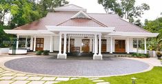 a white house with red roof and pillars