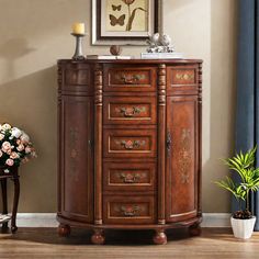 a wooden cabinet with drawers in a living room next to a painting on the wall