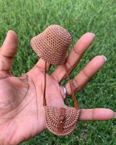 a hand holding a small crocheted hat on top of it's palm