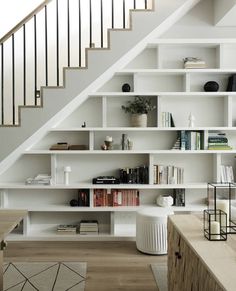 a white bookshelf filled with lots of books next to a stair case