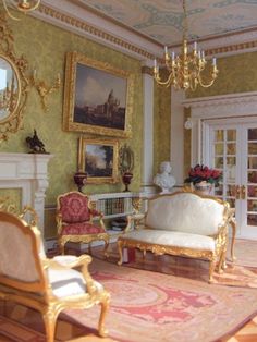 a living room filled with furniture next to a fire place under a chandelier