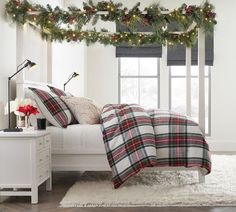 a bedroom decorated for christmas with garland and lights