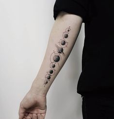 a person with a tattoo on their arm that has the sun and planets in it