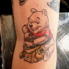 a winnie the pooh tattoo on someone's leg