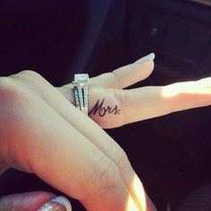 two hands with rings on their fingers and the word mom written on them, in front of a car door