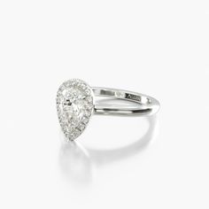 a pear shaped diamond ring on a white background