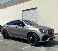 a silver mercedes suv parked in front of a building