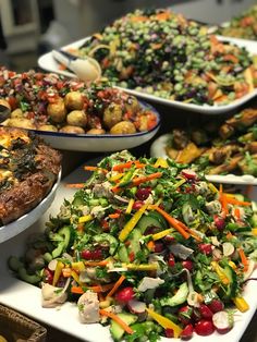 a table topped with lots of plates filled with food and salads next to each other