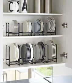 there are many plates on the shelves in this kitchen