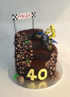 a birthday cake with dirt bike on top and number 40 sign in the middle,