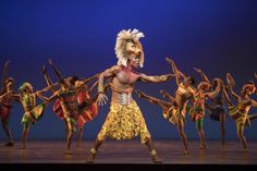 a group of people on stage with one man in costume