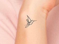 a woman's arm with a small tattoo design on the left side of her wrist