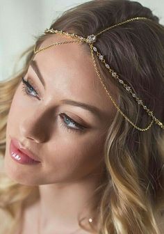 a woman wearing a gold chain head piece