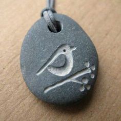 a stone with a bird on it sitting on top of a wooden table next to a string