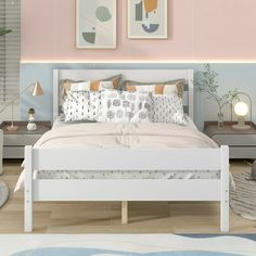 a bedroom with pink walls and white bedding, two framed pictures on the wall