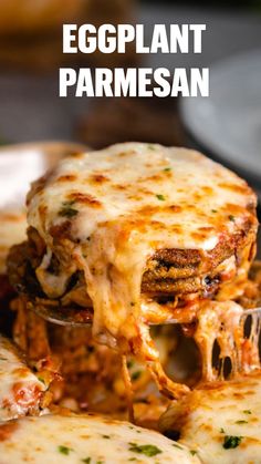 an eggplant parmesan is being lifted from a plate