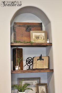 two wooden shelves with pictures and other items on them