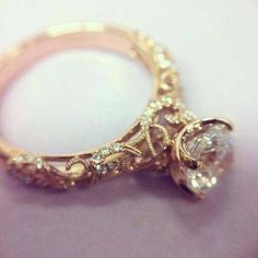 a close up of a gold ring with a diamond on the center and side stones