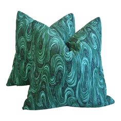 two green and blue pillows sitting on top of each other