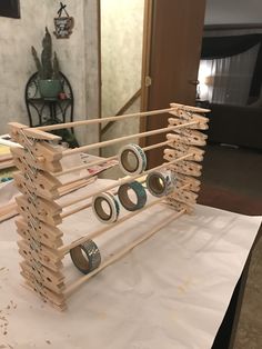 a wooden rack with tape on top of it sitting on a table in front of a mirror