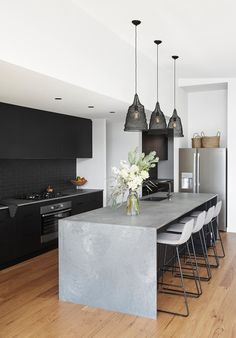 a modern kitchen with black cabinets and stainless steel countertops is pictured in this image