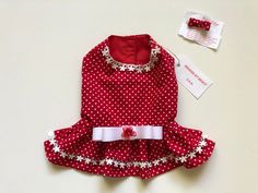 a red and white polka dot dog dress next to a tag that says, hello kitty