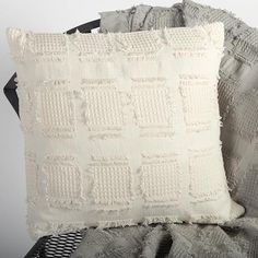 two white pillows sitting next to each other on top of a black and white blanket