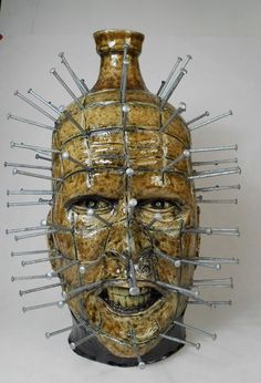 a ceramic face with spikes on it's head is shown in front of a white background