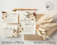 the wedding stationery is laid out on top of an envelope and some dried flowers