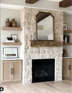 a living room with a fire place and wooden shelves on the wall, along with a large mirror above it