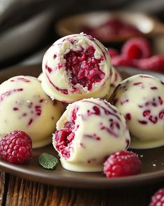 raspberry truffles on a plate with fresh raspberries