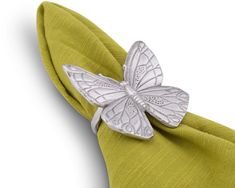 a close up of a napkin with a butterfly on it's side and a green cloth