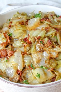 a close up of a bowl of food with meat and vegetables in it on a table